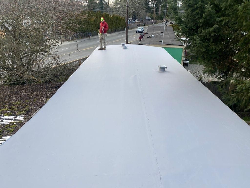 Team Roofing NW applying durable TPO membranes for energy efficiency.