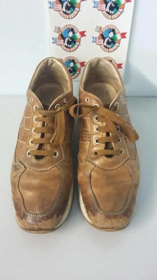 Un paio di scarpe da ginnastica marroni sono appoggiate su un tavolo bianco.