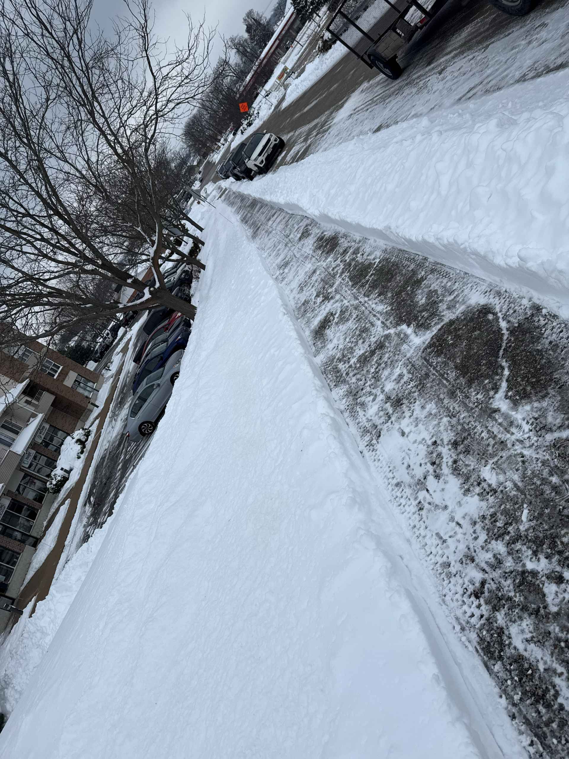 Woman in straw hat smiles, holding wine glass near a lake.