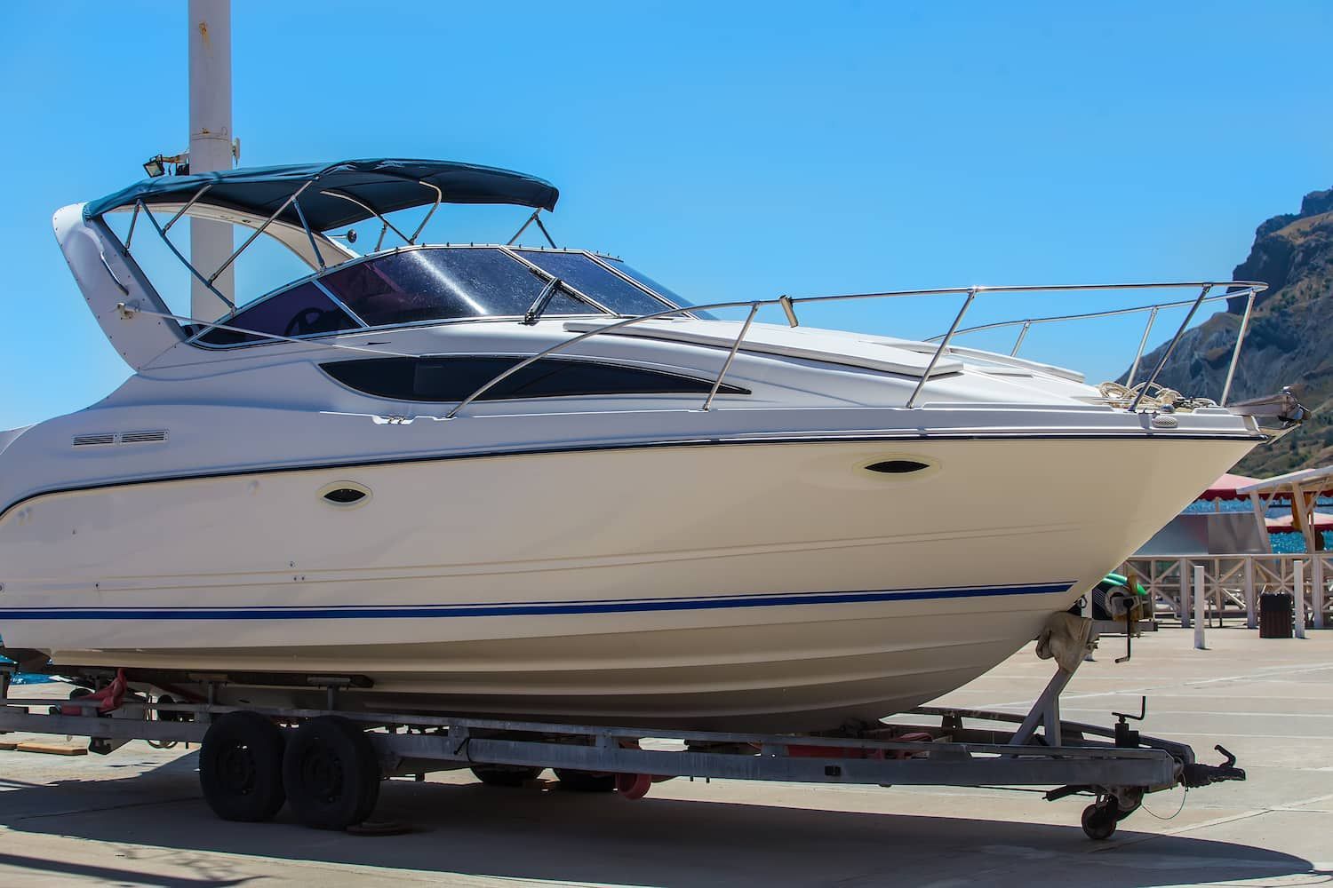 White Motorboat on a Trailer, With a Blue Canopy, Parked Outdoors Under a Clear Sky — BCV Storage Centre in Wauchope, NSW