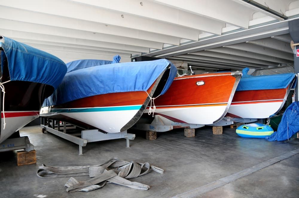 Boats Covered With Blue Tarps in an Indoor Storage Space — BCV Storage Centre in Wauchope, NSW