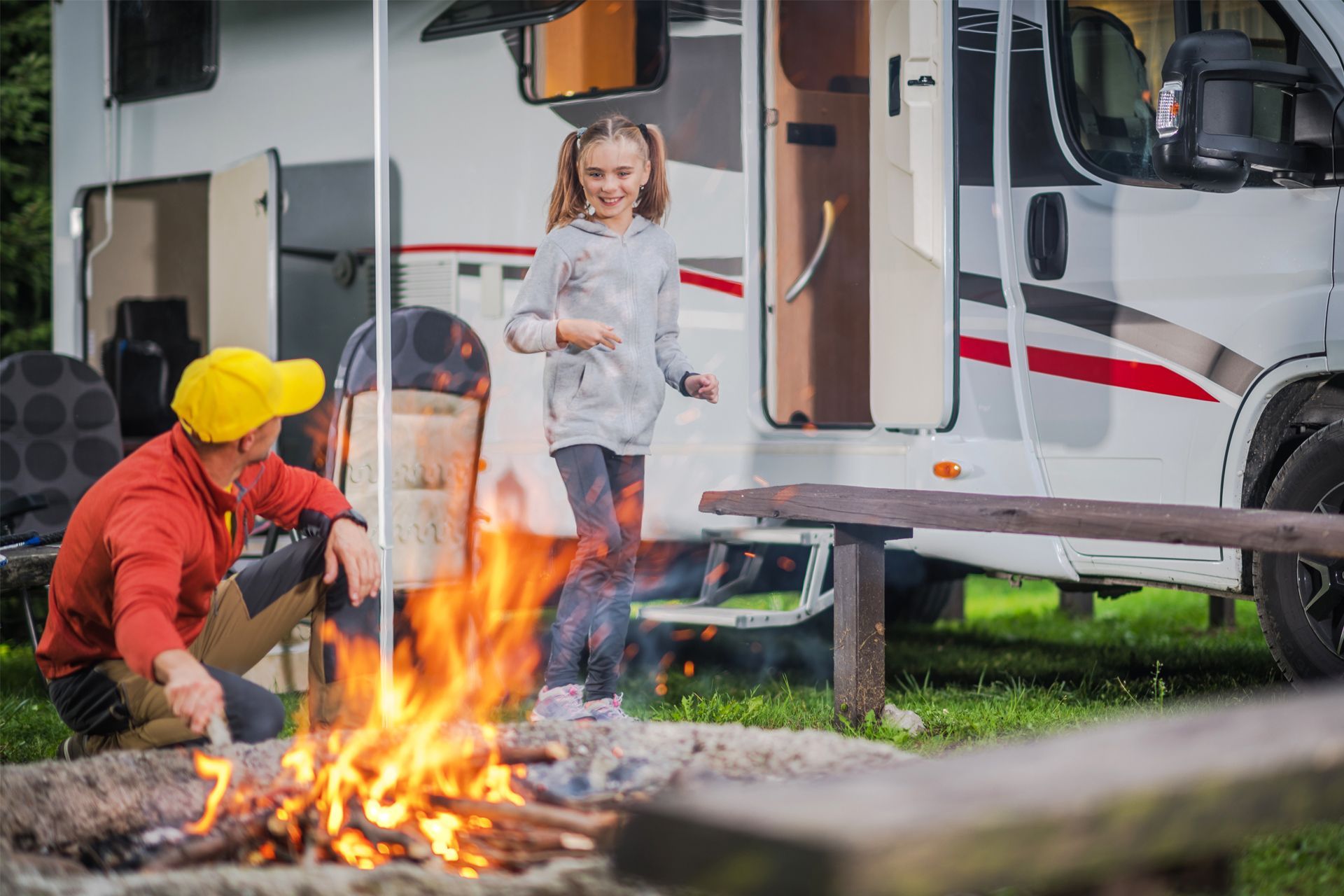 Father and Daughter Making a Campfire in Front of RV