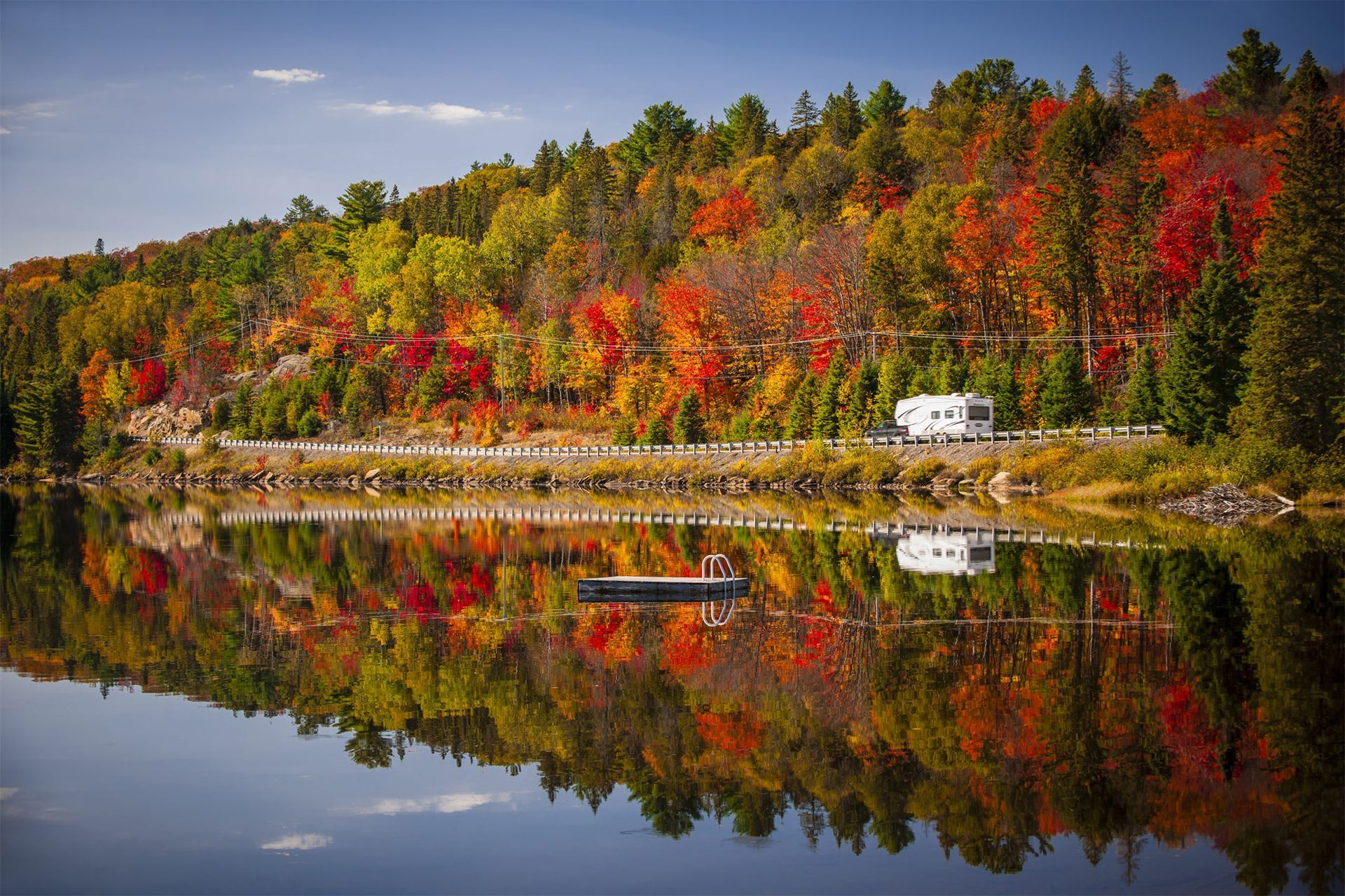 RV Beside Lake Surrounded by Trees in Autumn
