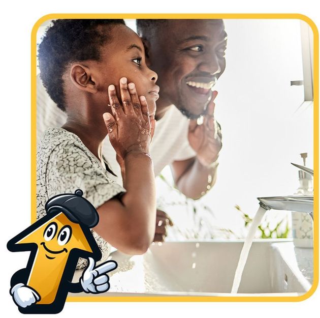 Father and child washing their faces together in a bathroom, near a sink and a mirror.