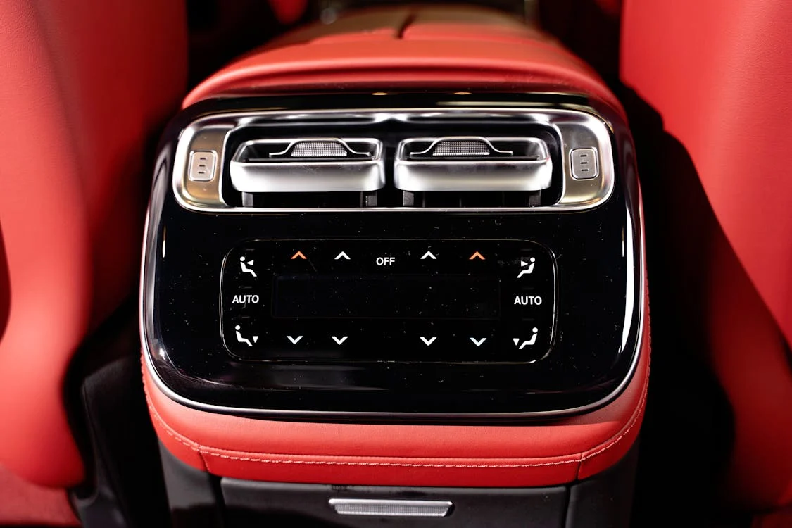 Rear car console with climate controls, black, silver, and red; likely luxury vehicle | Moore's Automotive Repair LLC