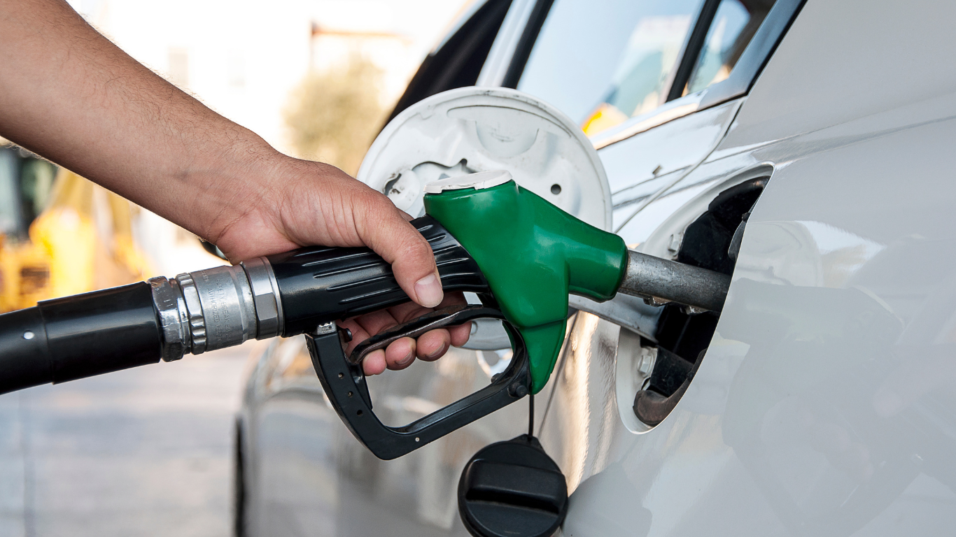 A person is pumping gas into a car at a gas station.