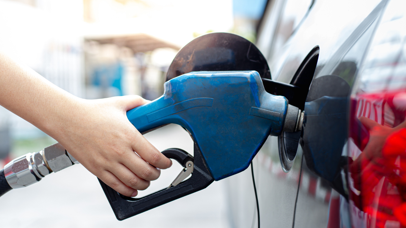 A person is pumping gas into a car at a gas station.