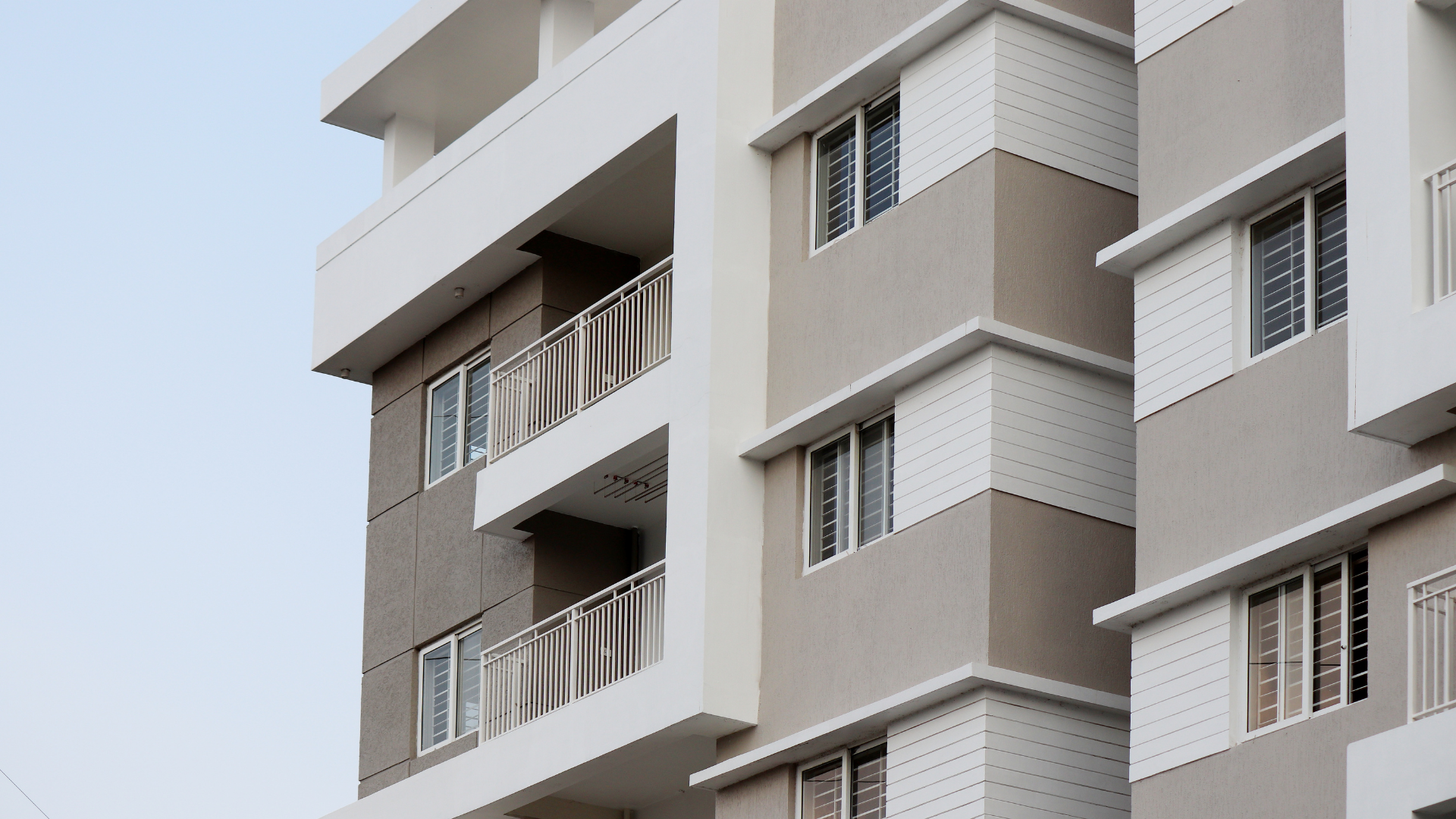 Multi-story apartment building with white and gray facade.