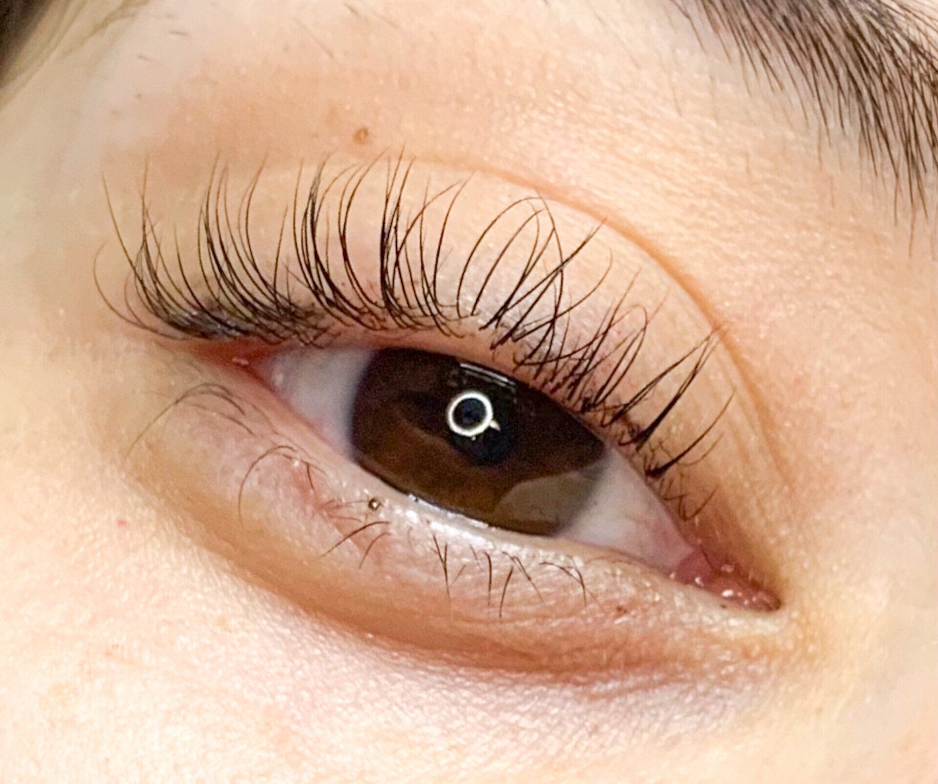 A close up of a woman 's eye with long eyelashes.