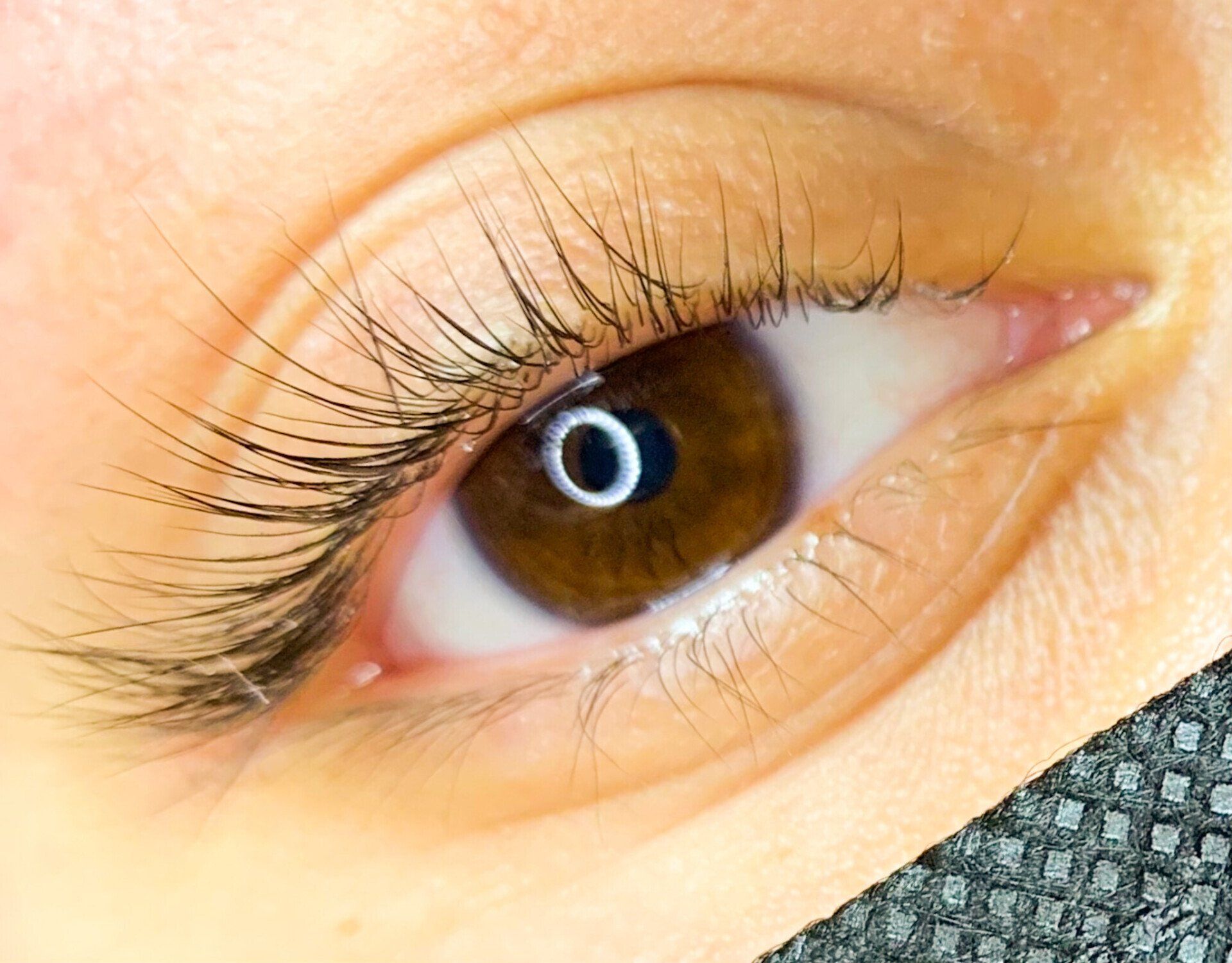 A close up of a woman 's eye with long eyelashes.