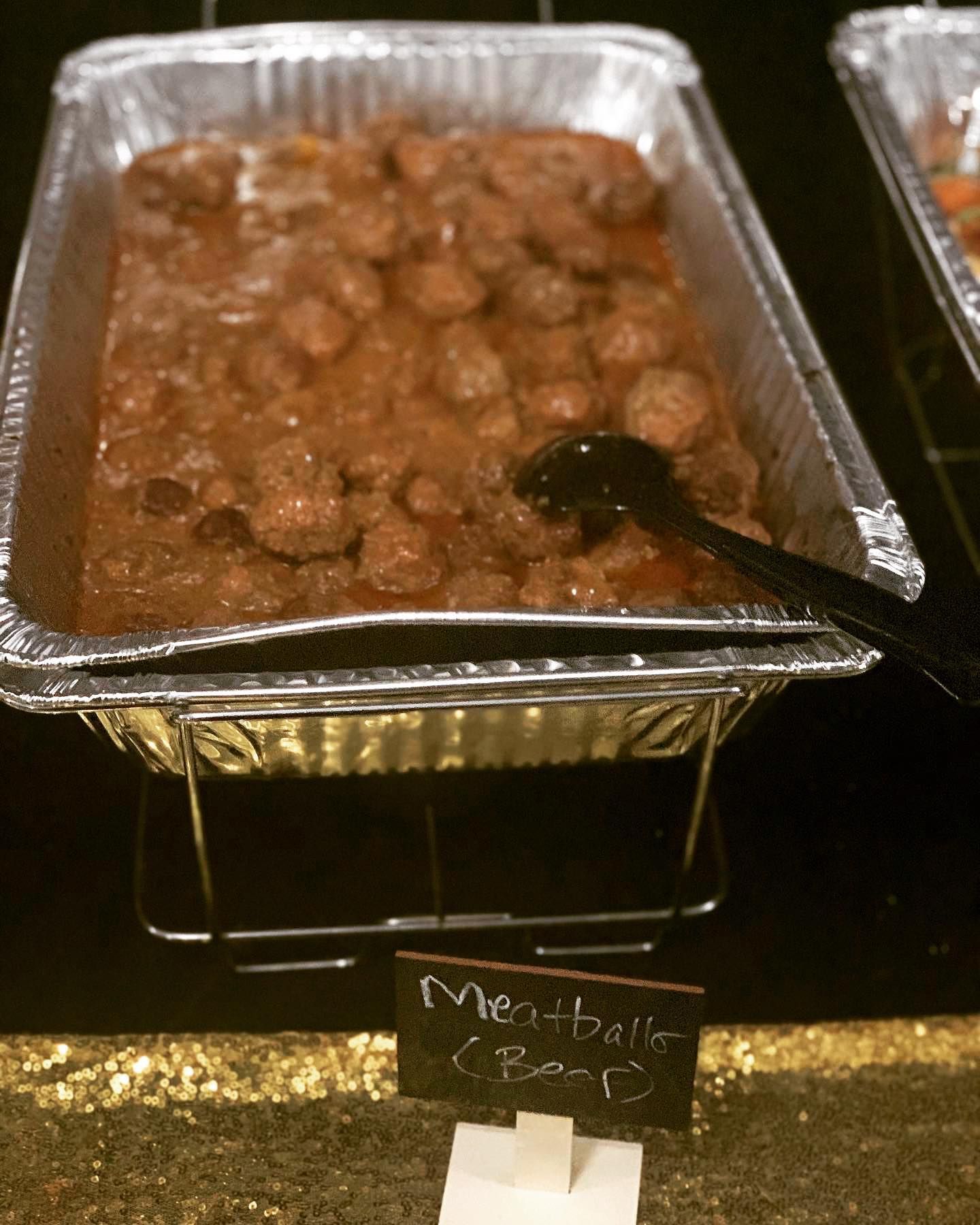 A tray of meatballs with a spoon in it