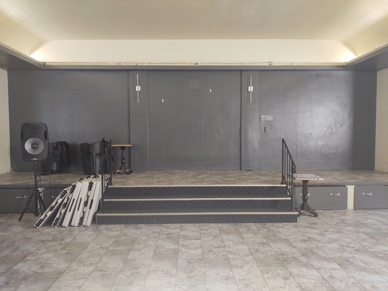 There is a stage with stairs in the middle of the room.