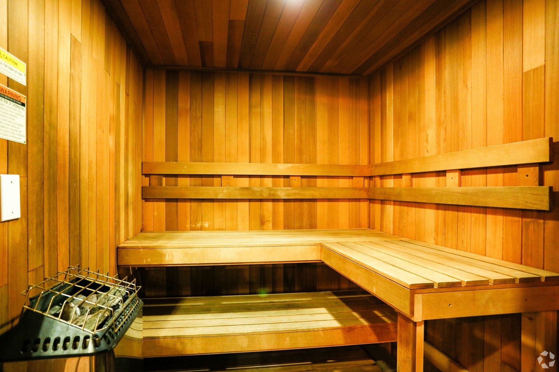 Wooden sauna interior with benches and heater.