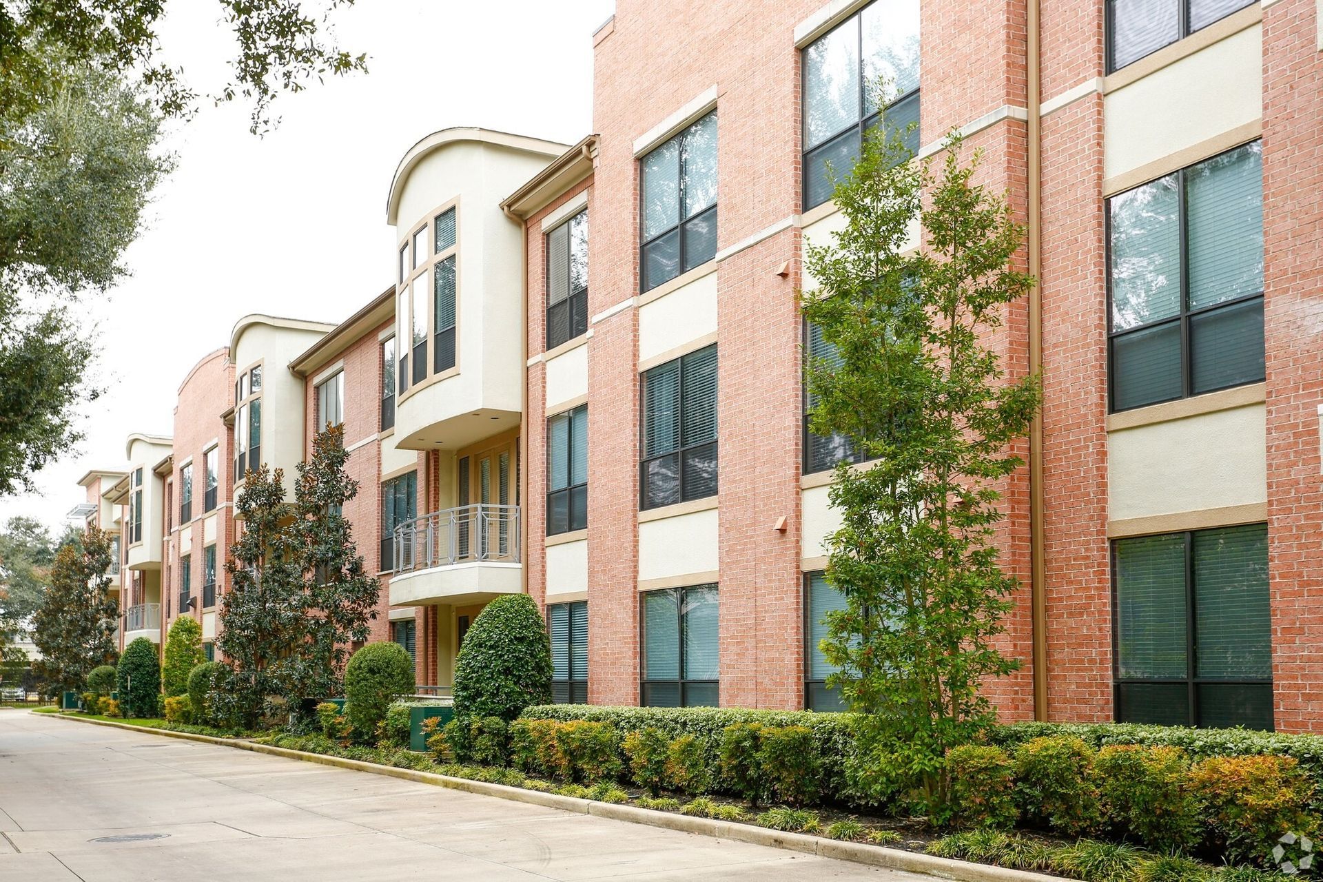 Brick apartment building with multiple stories and large windows.