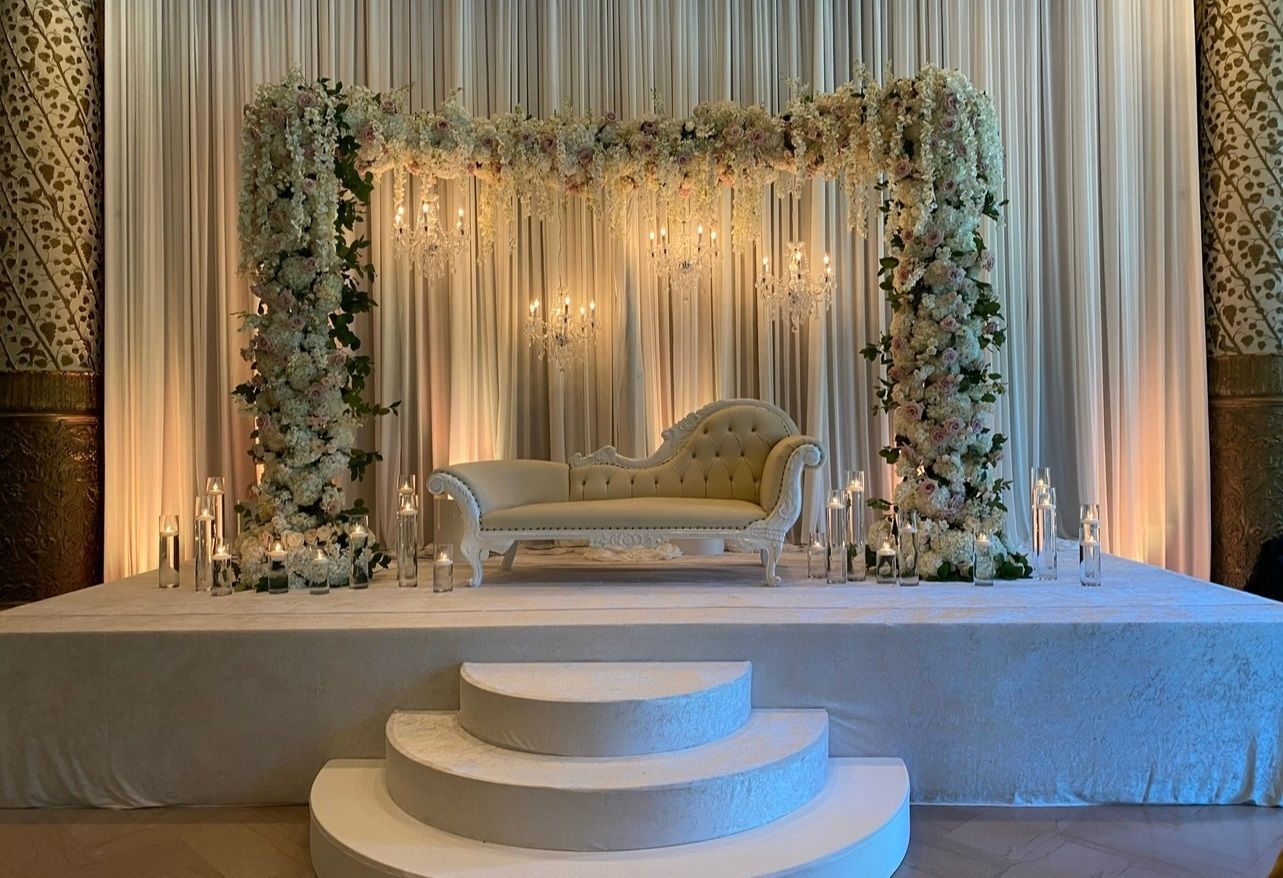 A wedding stage with a couch and flowers on it.