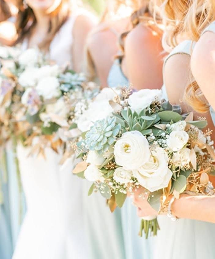 A group of bridesmaids are holding bouquets of flowers.