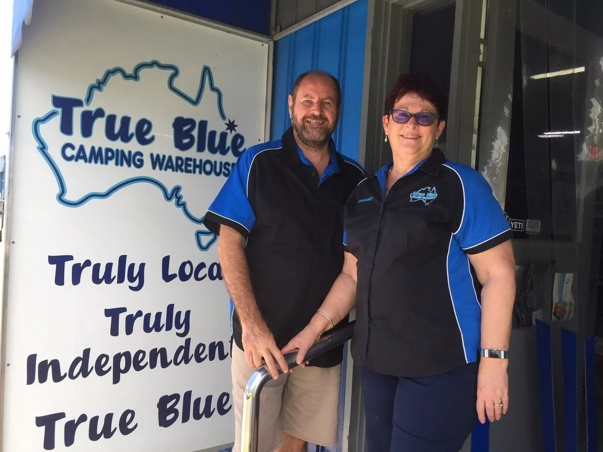 Two People, Standing in Front of a Blue Camping Warehouse Sign — True Blue Camping Warehouse in North Mackay, QLD