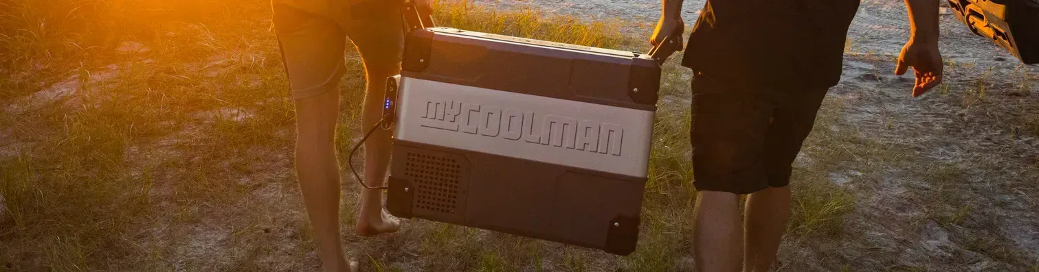 Two People Carrying a Black and White Object — True Blue Camping Warehouse in North Mackay, QLD