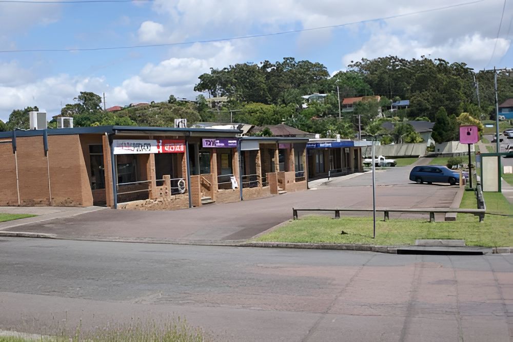 A Row of Shops Are Lined Up on the Side of the Road — Craig Hughes Podiatry in Mount Hutton, NSW