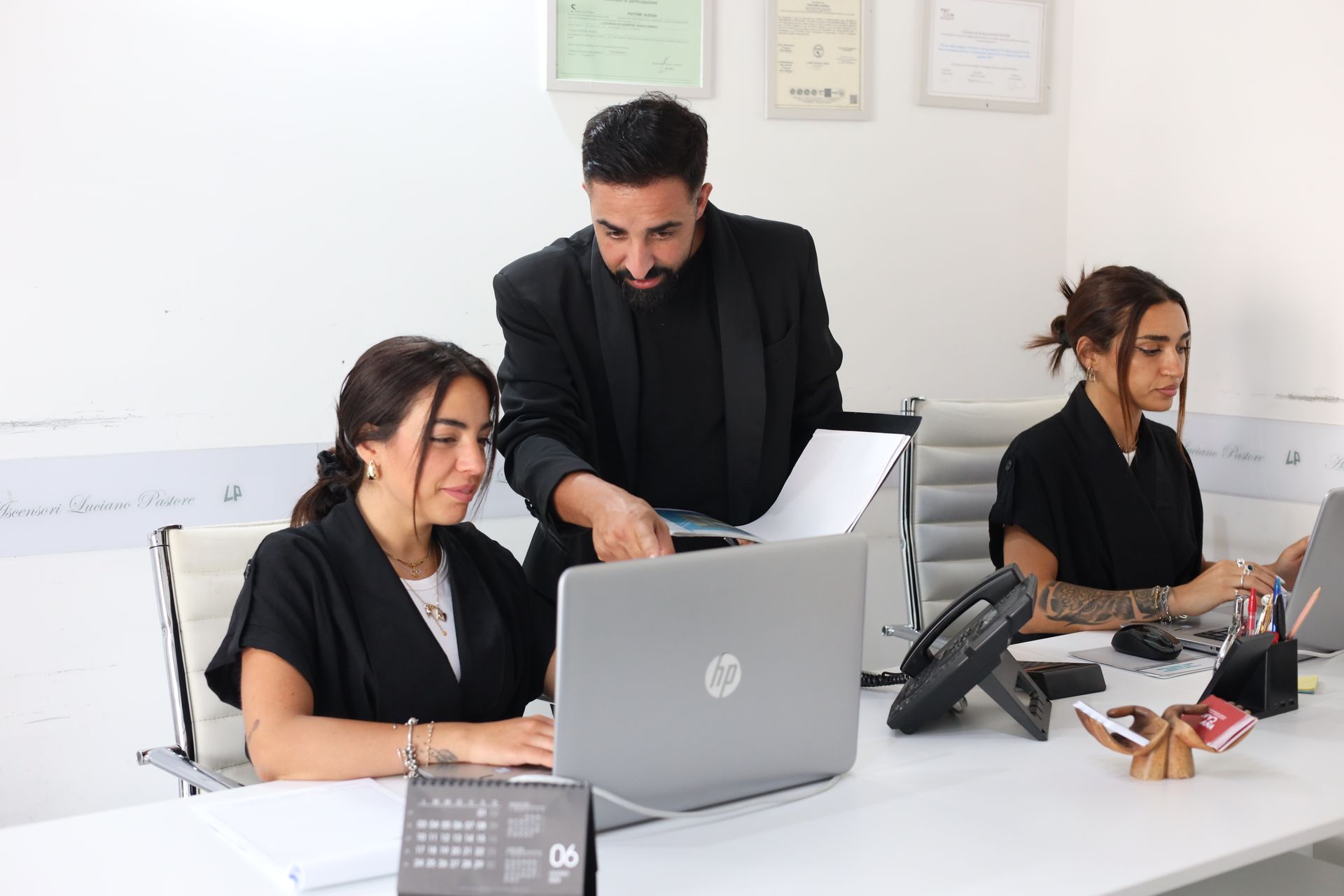 Un uomo e due donne lavorano sui laptop in un ufficio.