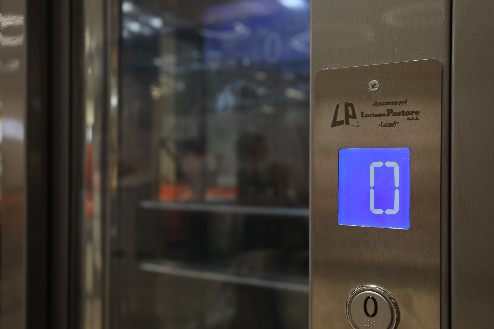 Un primo piano di un pulsante dell'ascensore con sopra il numero 0.