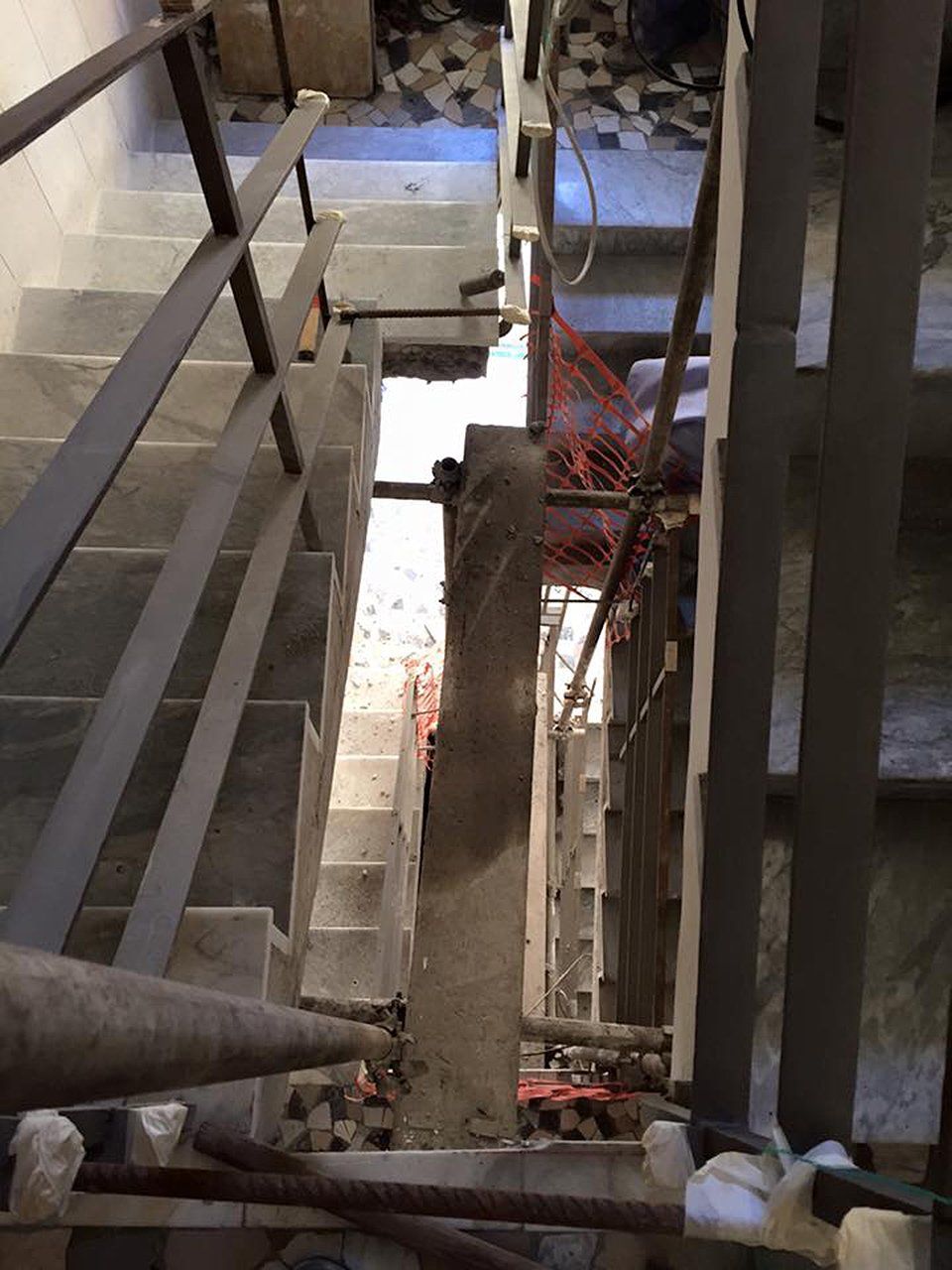 Vano scala con gradini in cemento e ringhiere metalliche, vista dall'alto. .