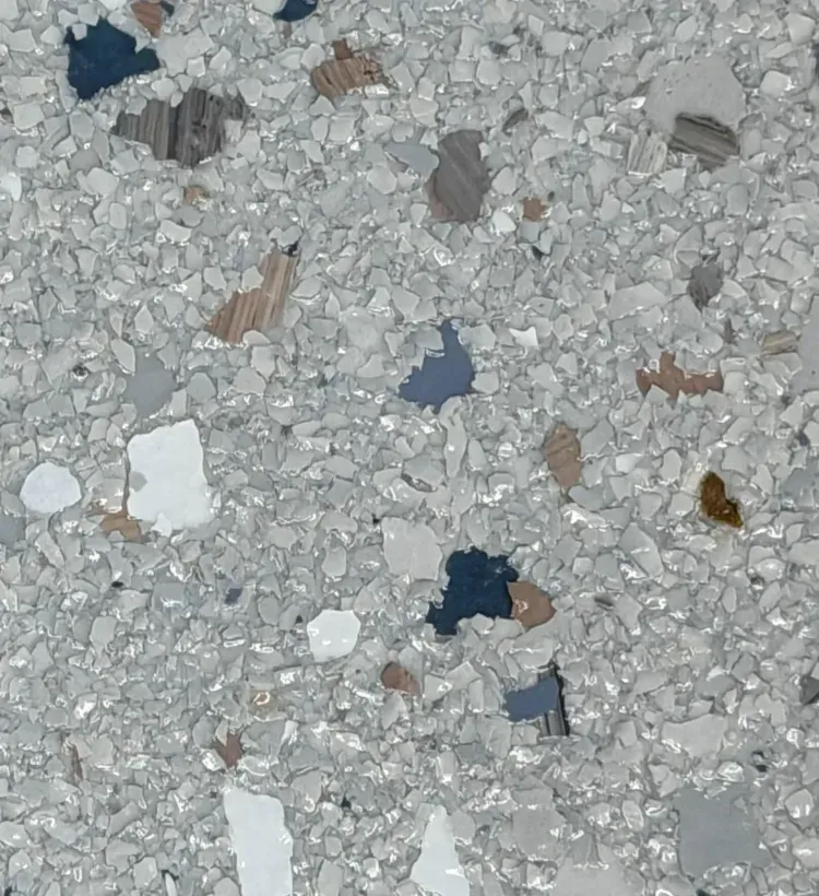 Close-up of light gray speckled terrazzo flooring with small colored stone chips