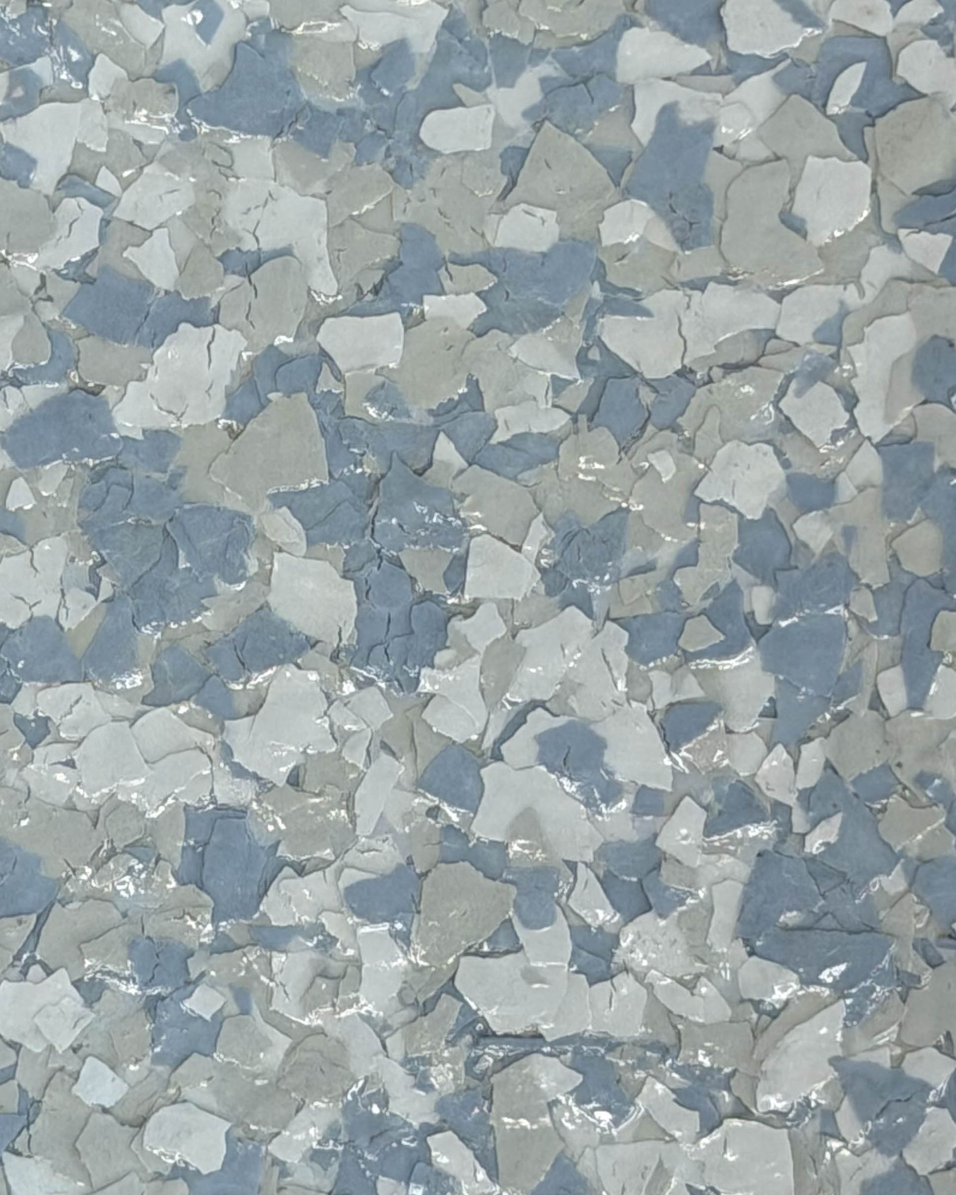 Gray and white speckled terrazzo-like surface with scattered dark chips