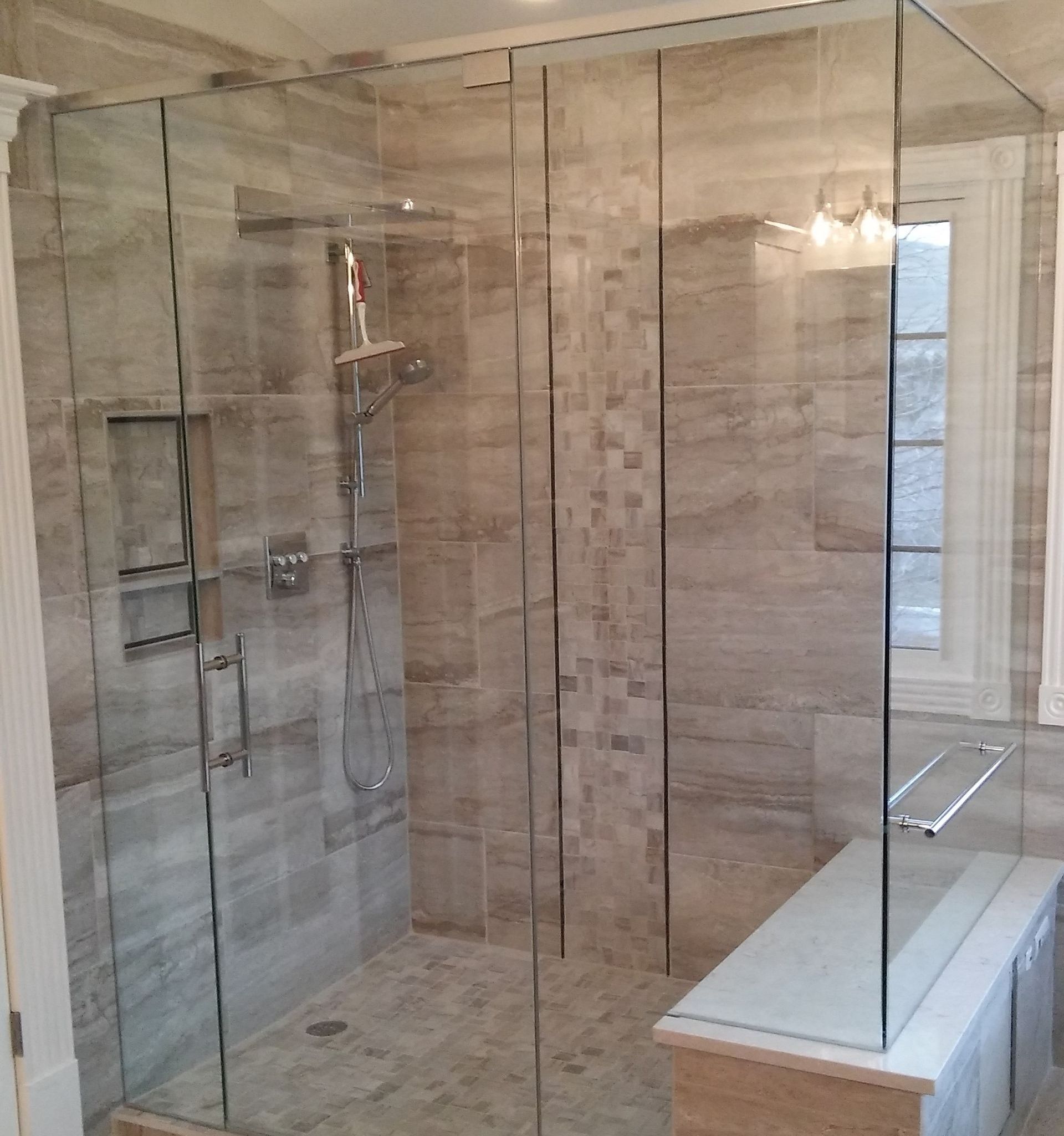Frameless glass walk-in shower enclosure with marble tile by Highlands Ranch Glass