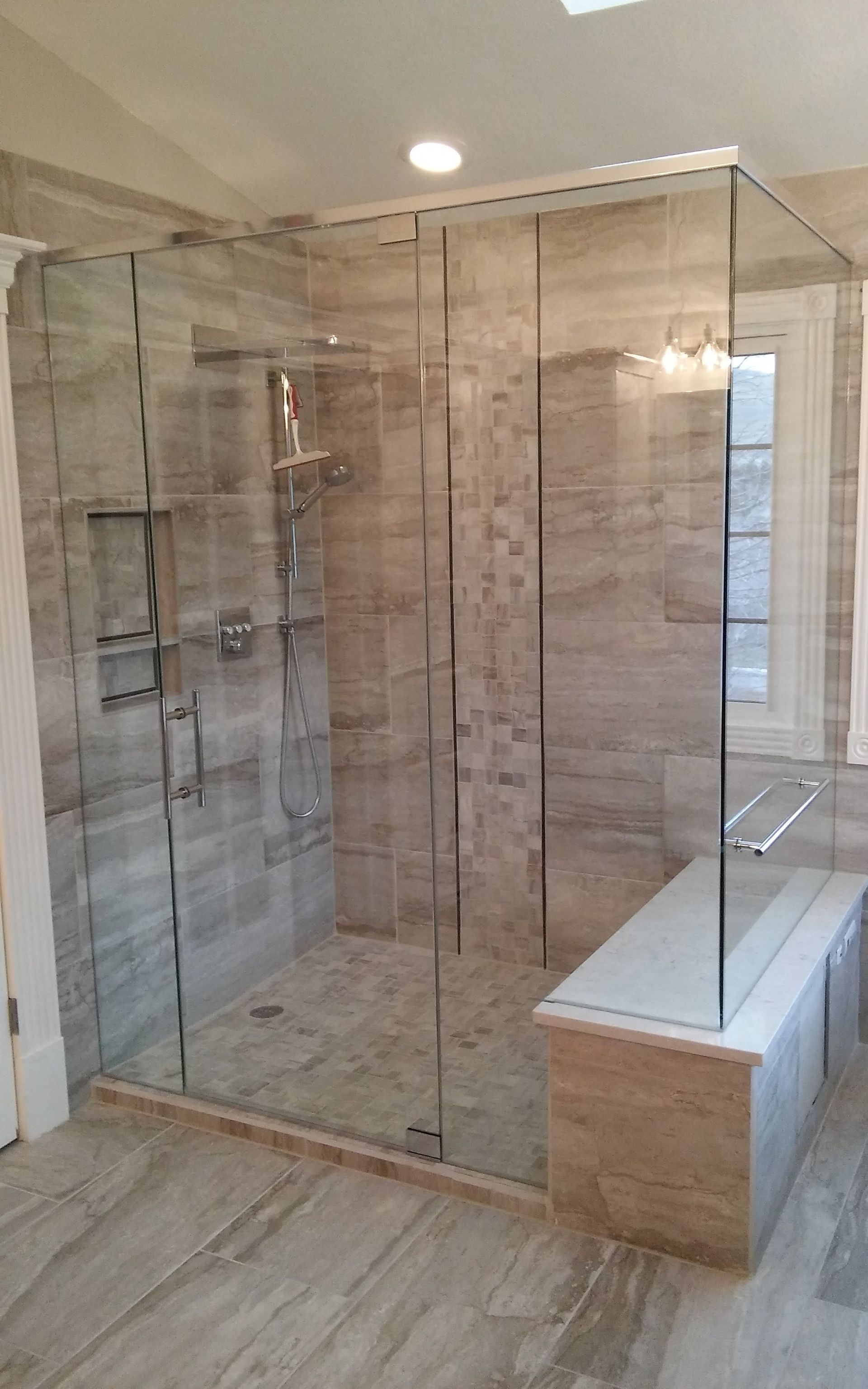 Frameless shower enclosure with geometric tile
