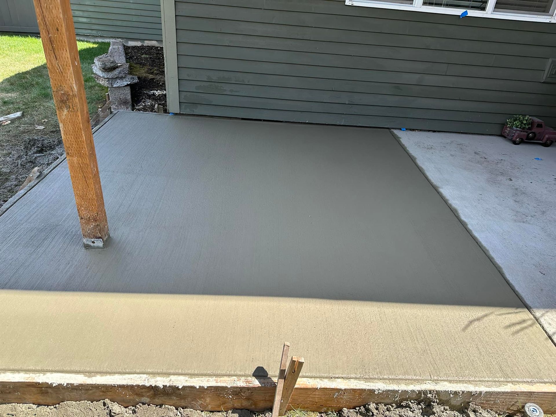A concrete patio is being built in front of a house.