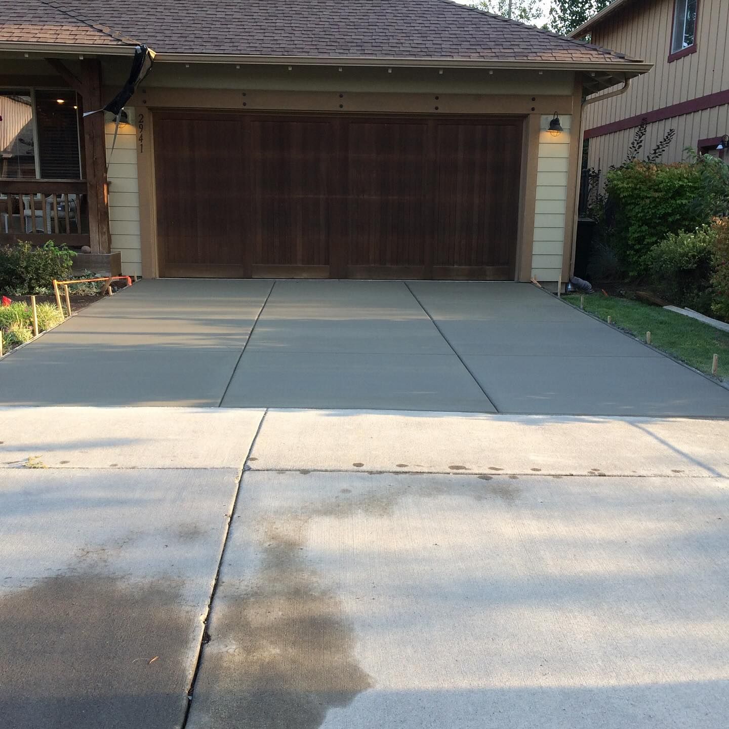 A driveway leading to a house with a wooden garage door