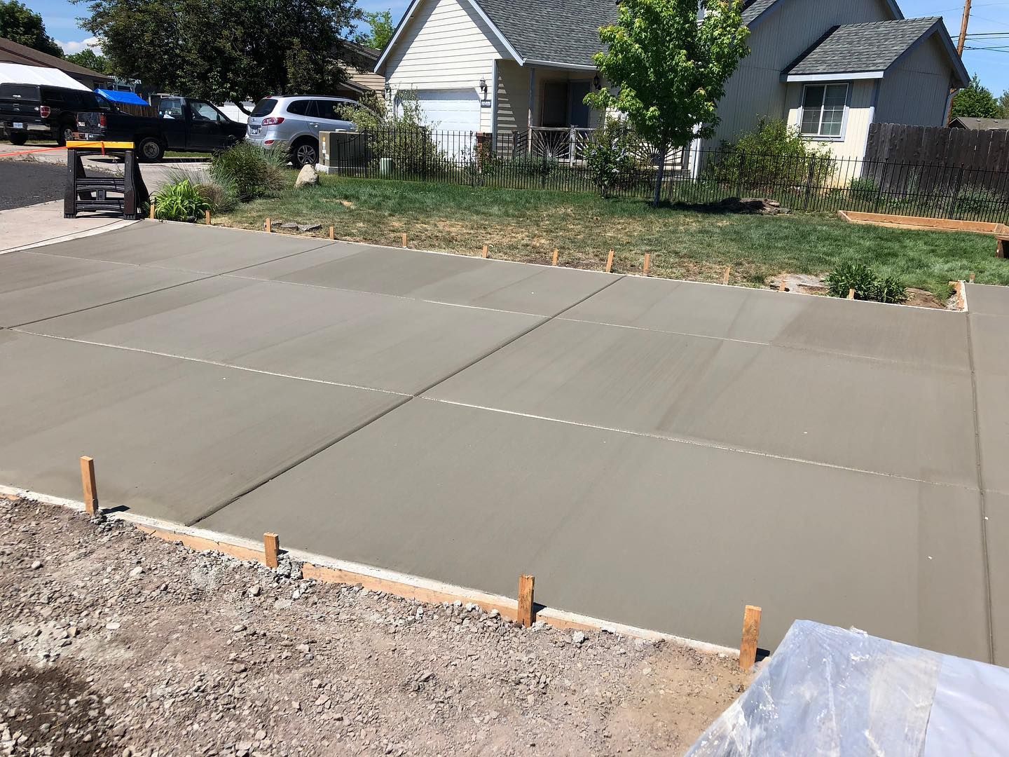 A concrete driveway is being built in front of a house.