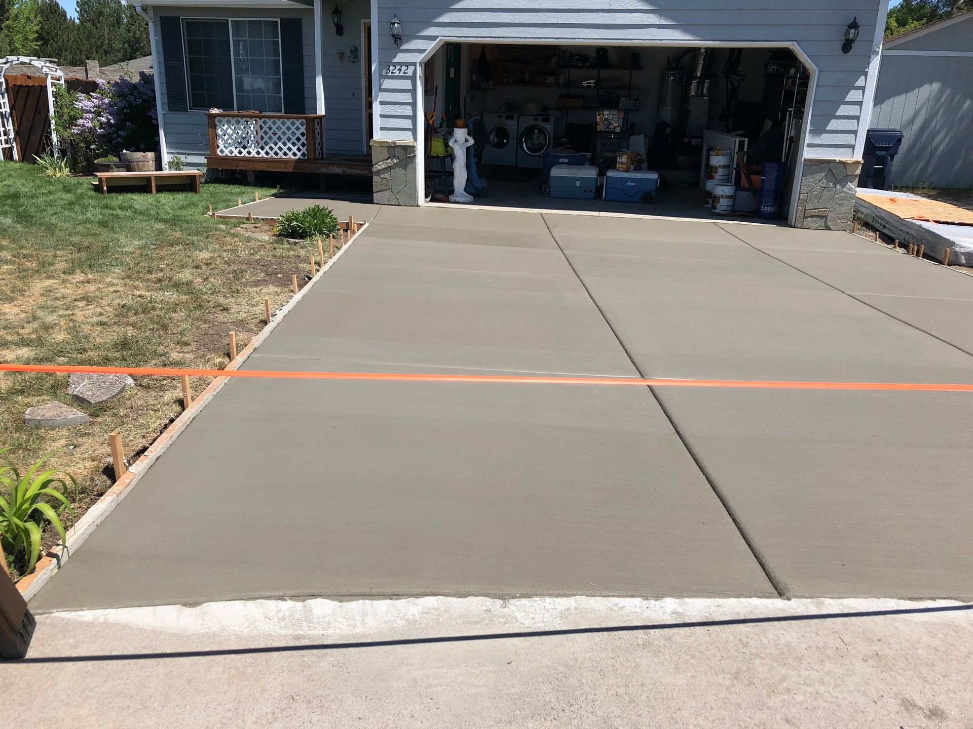 A concrete driveway is being built in front of a house.
