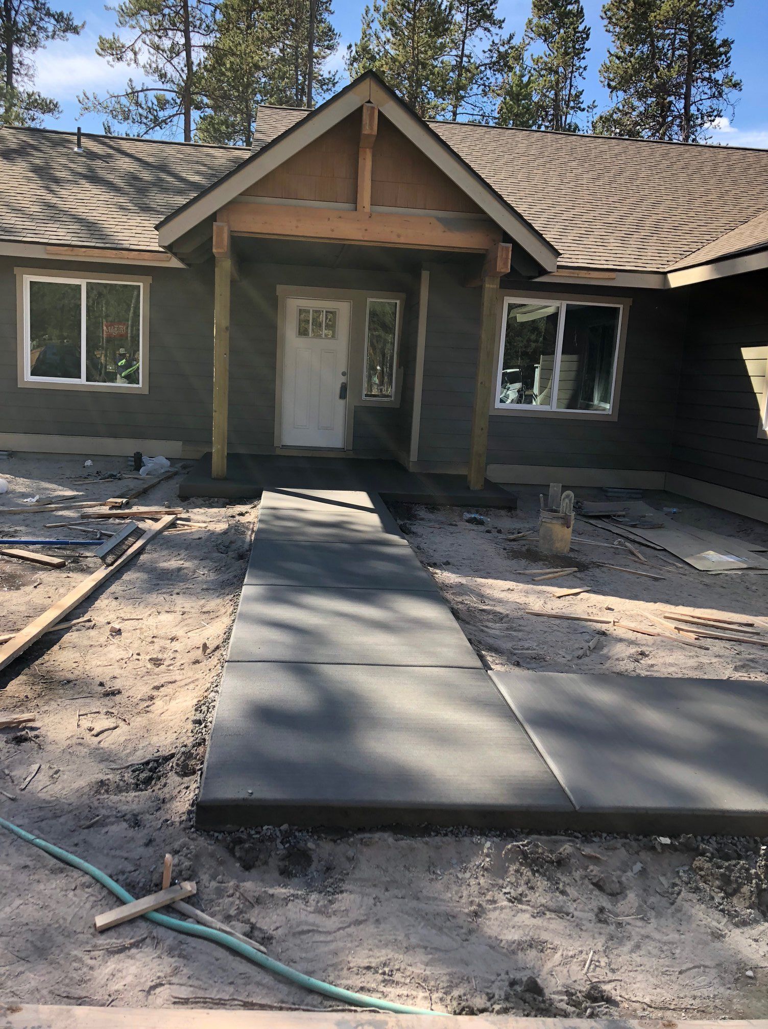A concrete walkway is being built in front of a house.