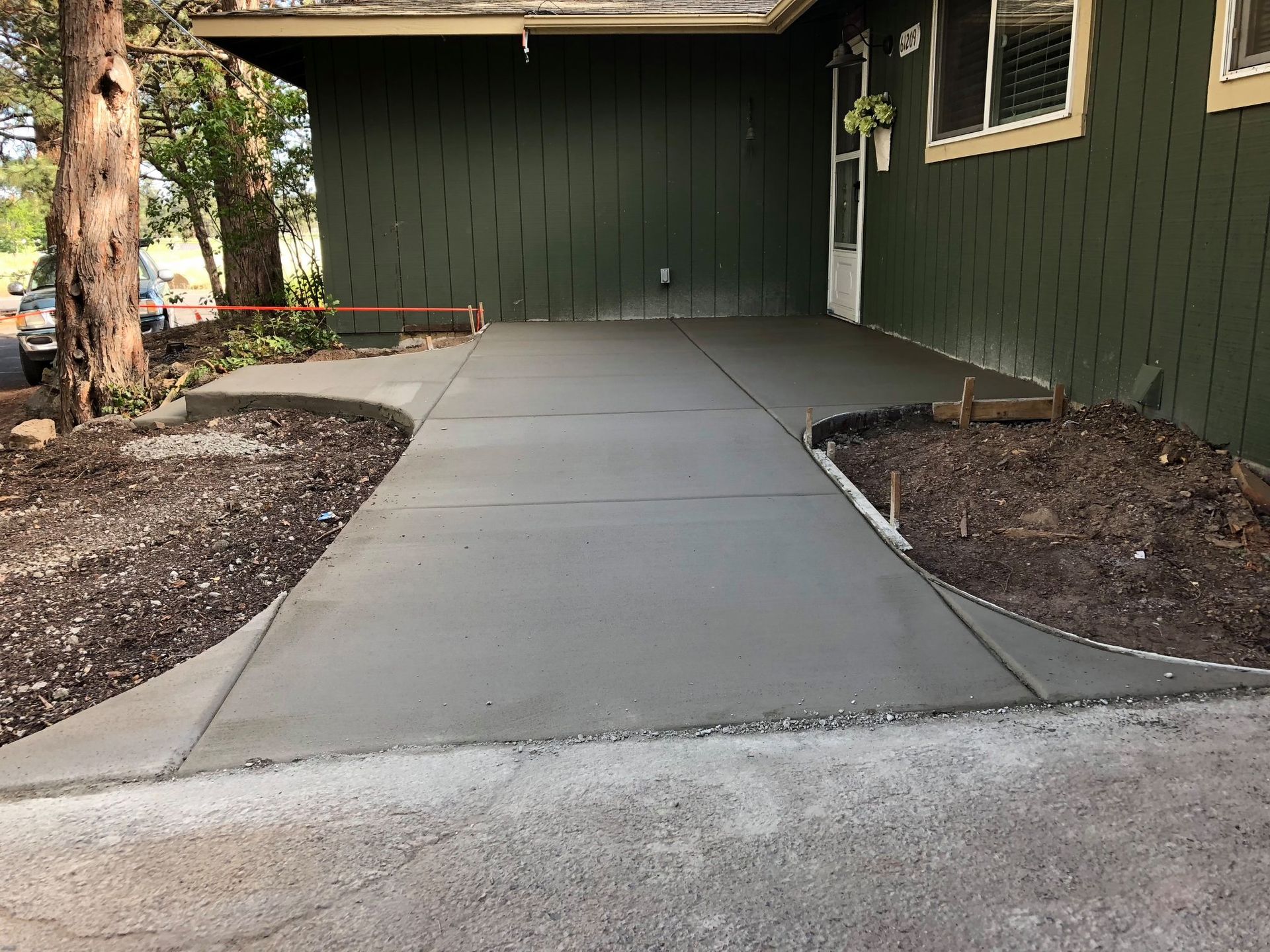 A concrete walkway is being built in front of a house.