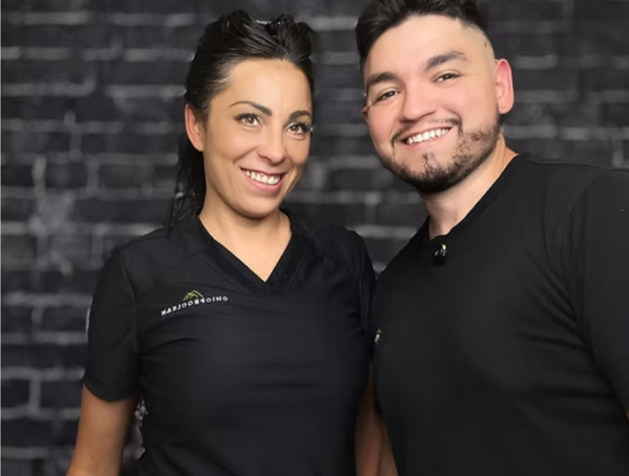 Business owners standing in front of brick wall