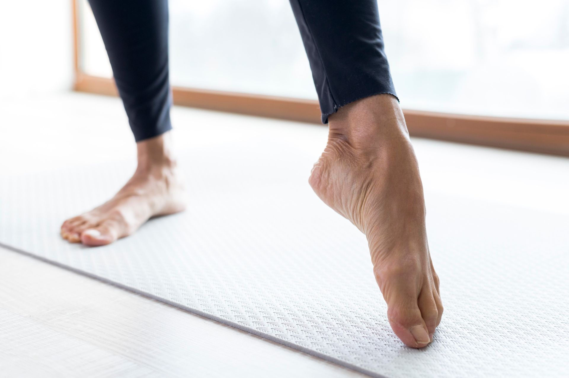 A close up of a person 's feet on a yoga mat.