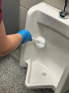 A woman is cleaning a dental chair in a dental office.