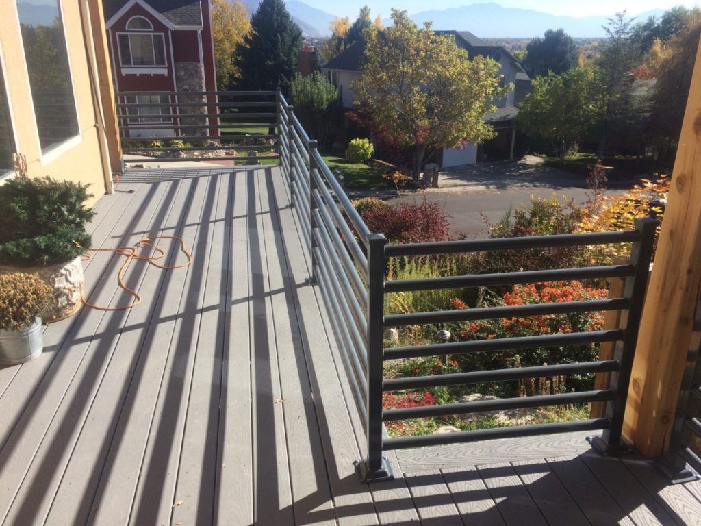 Composite deck with metal railing overlooking a street with colorful autumn foliage.