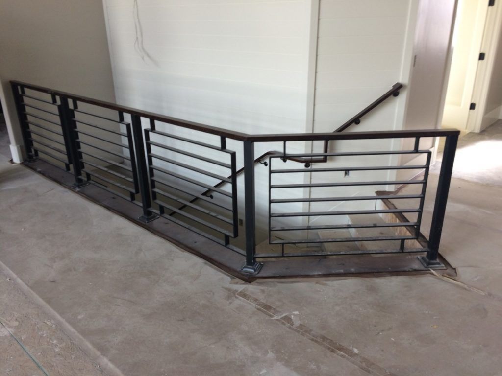 Black metal staircase railing in an unfinished building.
