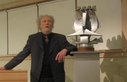 Erlingur Jónsson listamaður stendur við styttu.