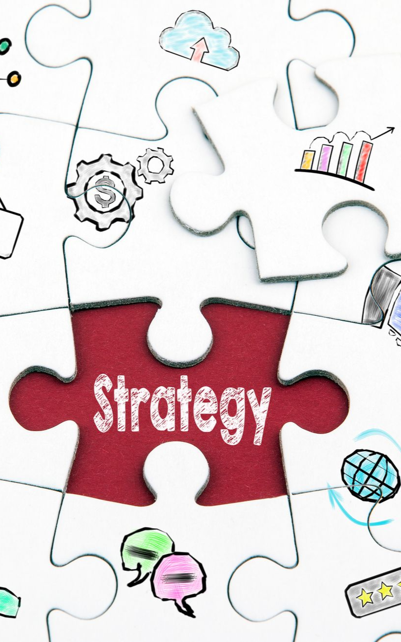 Two people reviewing charts on a laptop and tablet at a table, discussing data with a pen.