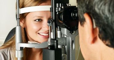 Optometrist examines the eye of a young woman