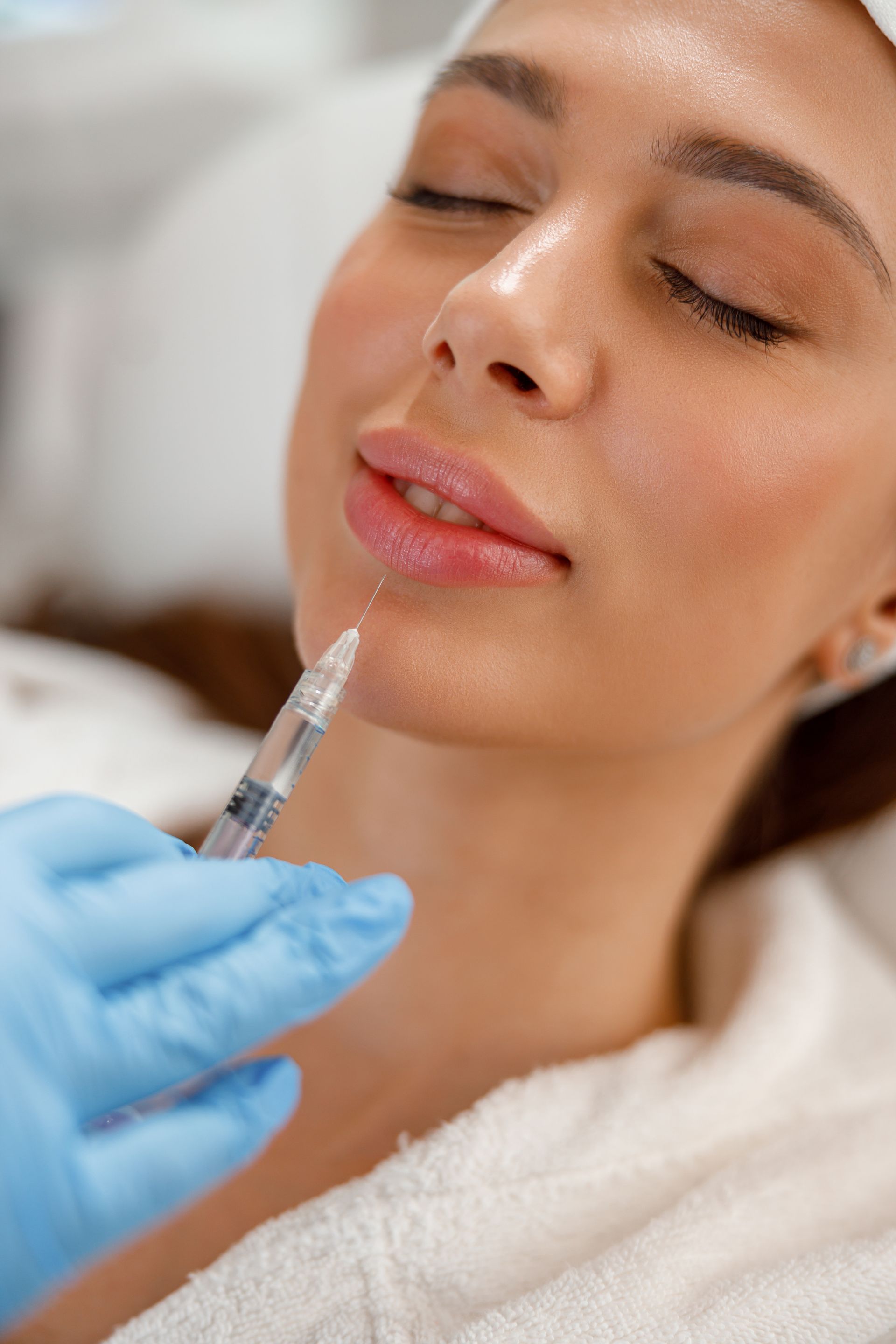 closeup of young woman getting rejuvenating injection treatment
