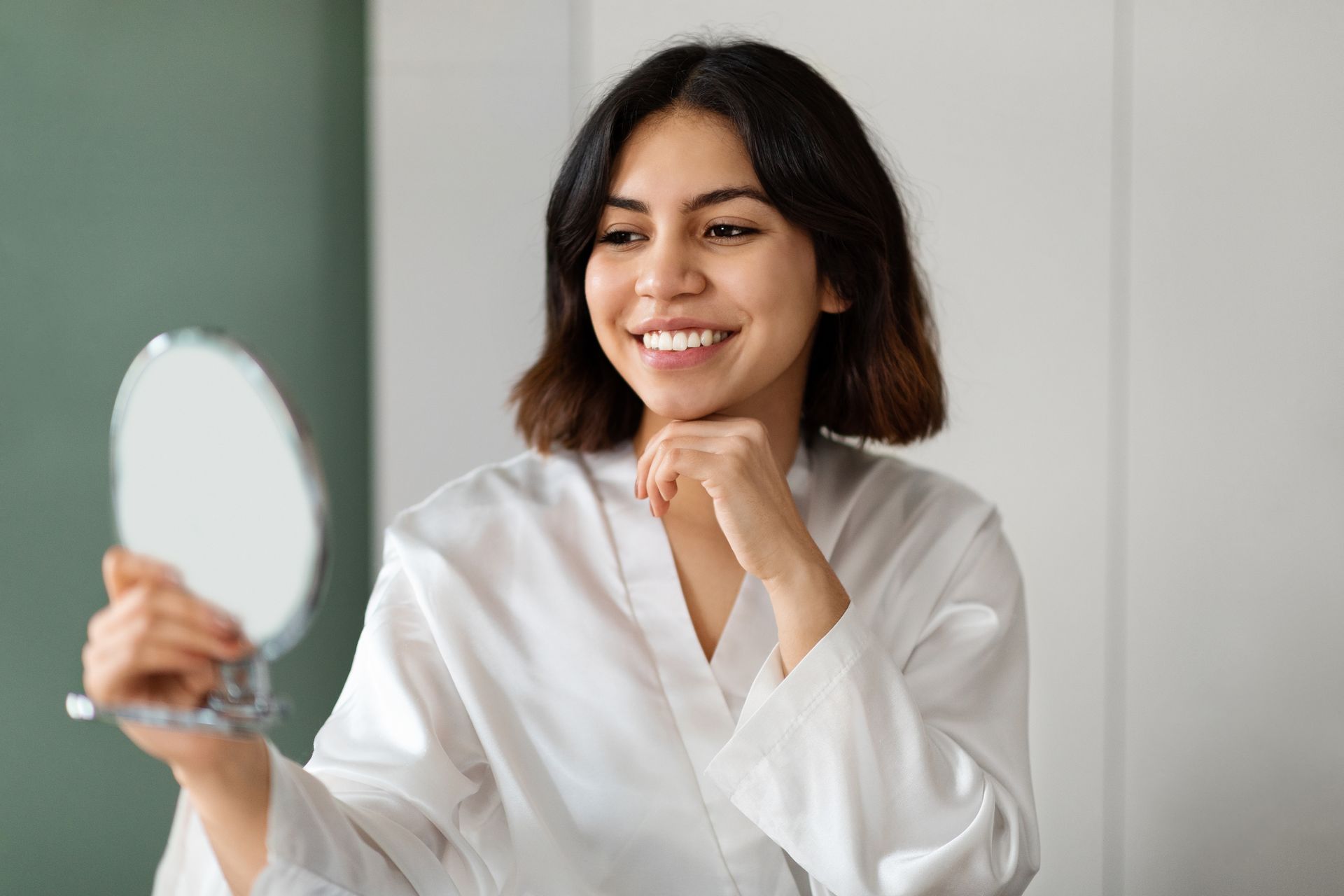 happy woman looking at face in mirror