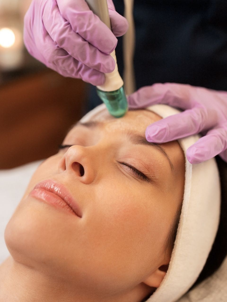 woman getting microdermabrasion done on face