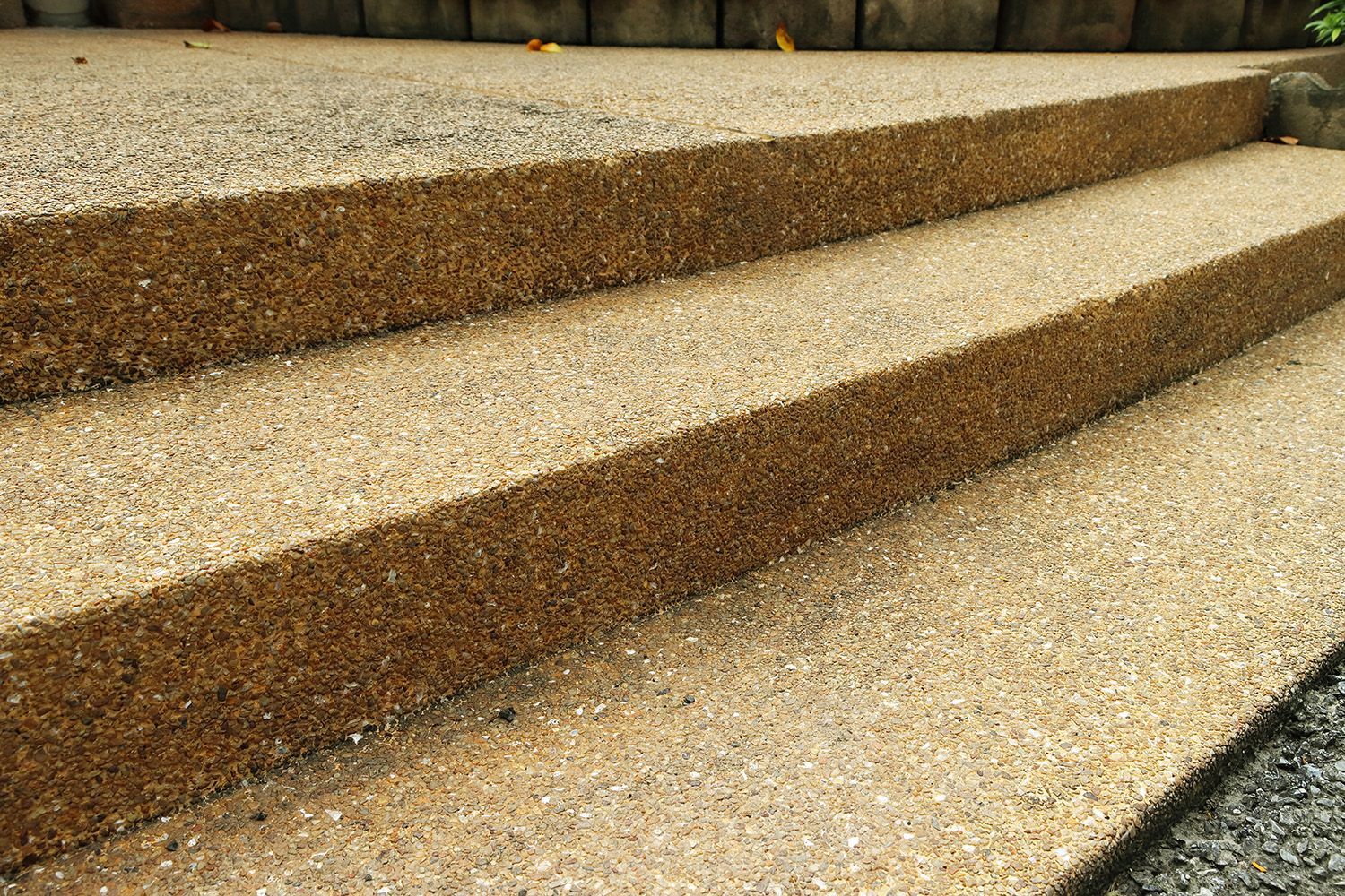 A close-up of exposed brown aggregate concrete steps.