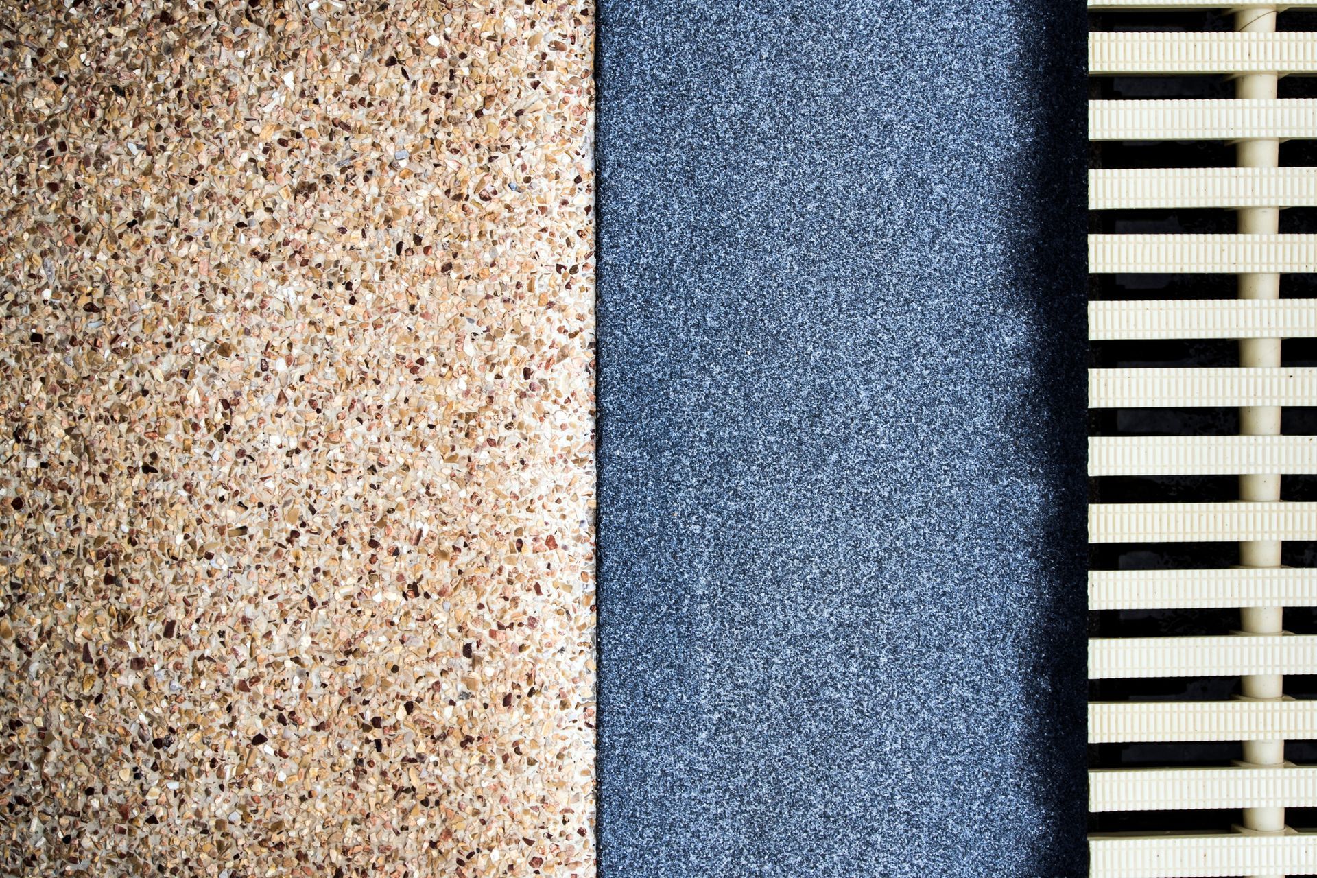 Different textures on an exposed aggregate flooring and the marble flooring and a plastic gutter cov