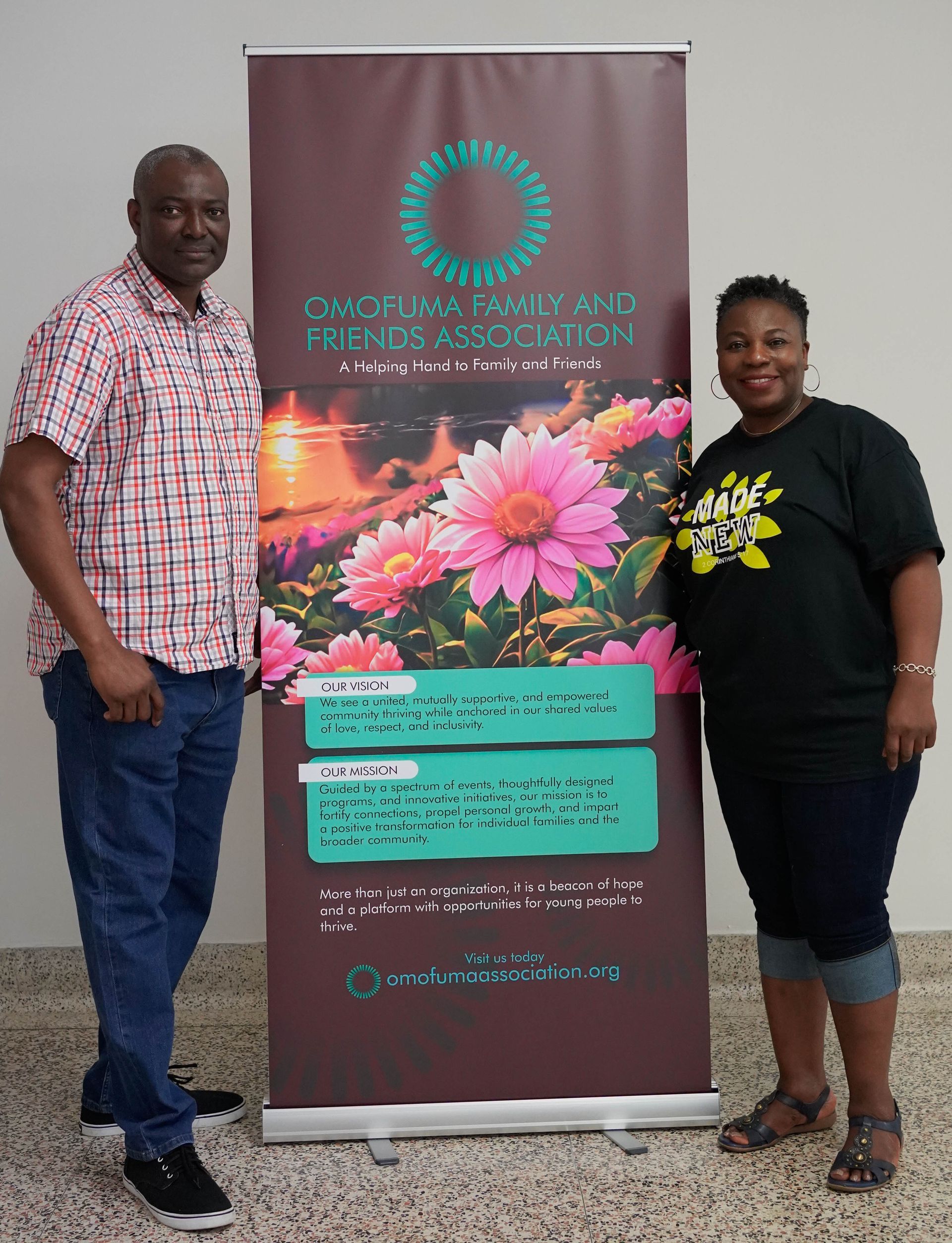 Man and woman stand next to a banner with flower image. The banner has text.